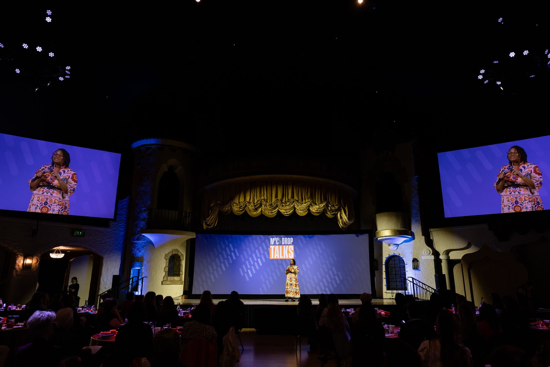 Makeda Boehm speaking on stage before a live audience